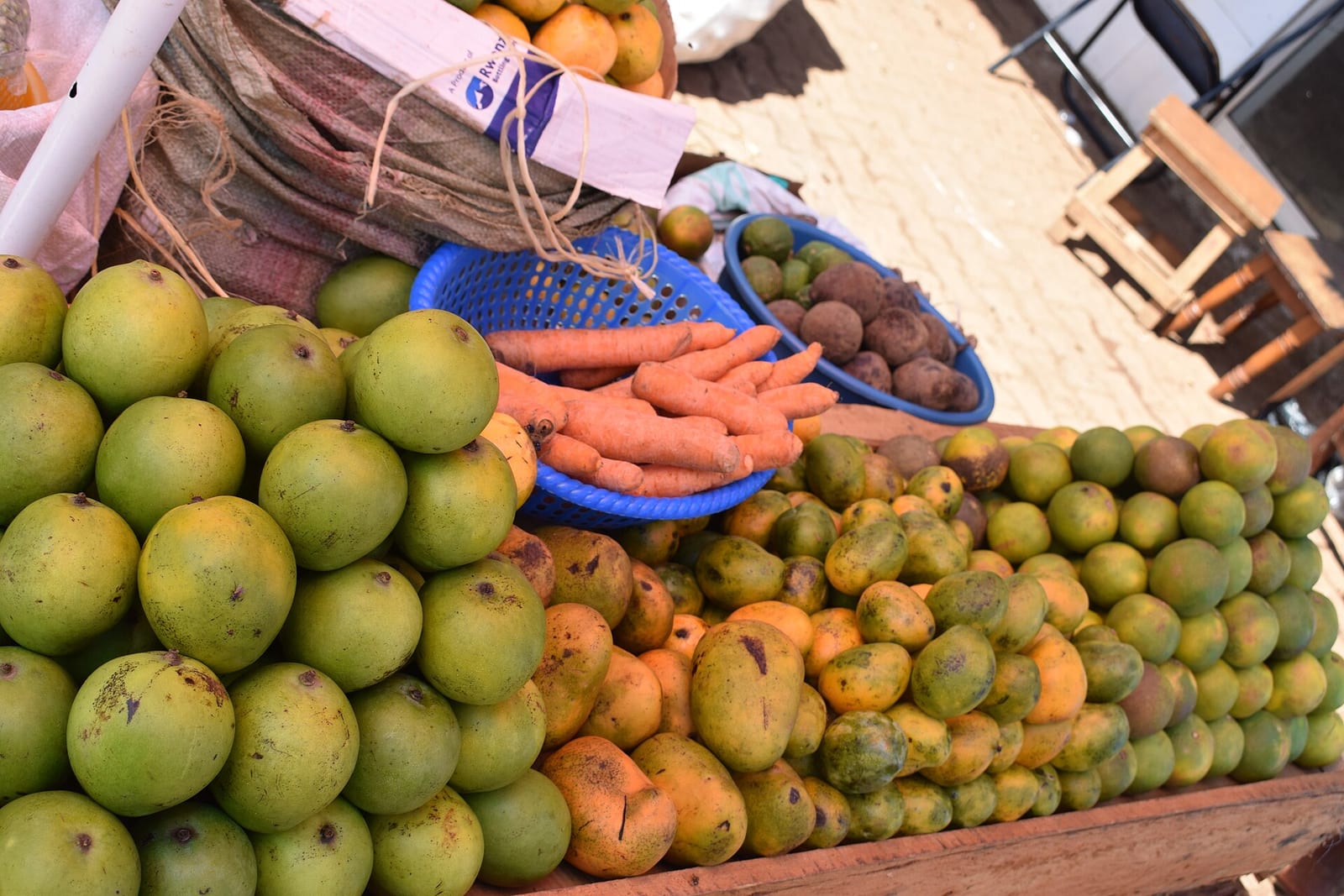 Pazar tezgâhında sergilenen mango, havuç ve taze ürünler